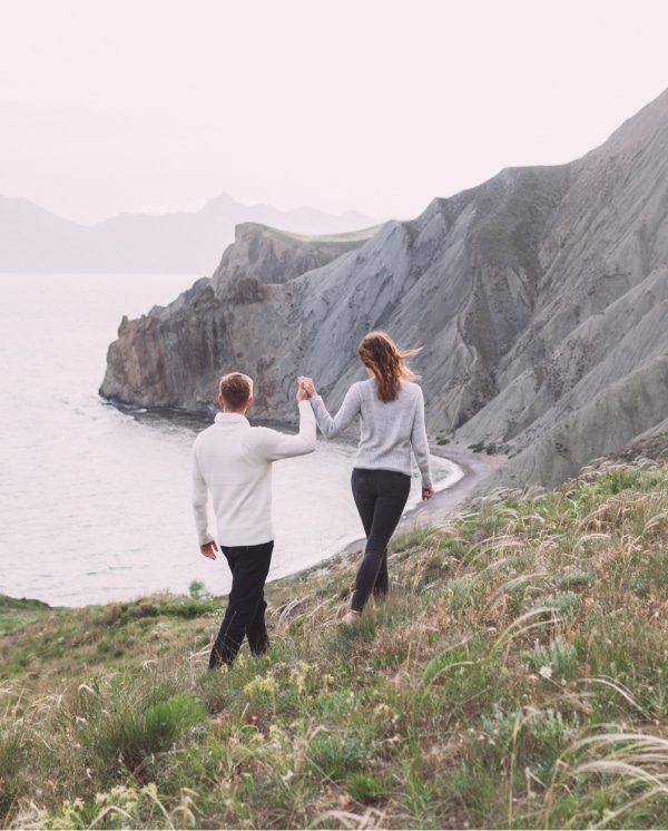 Journey Together: The Power of Zodiac Signs & Compatibility Couple walking by the sea holding hands, symbolizing zodiac signs & compatibility