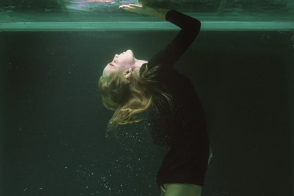 Woman underwater symbolizing the shadow self and emotional transformation